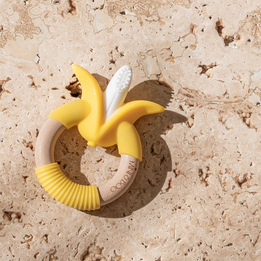 Mini and Boo banana teether made from food-grade silicone and beechwood – circular design with non-slip grip, naturally antibacterial, BPA and PVC free baby teether accessory.