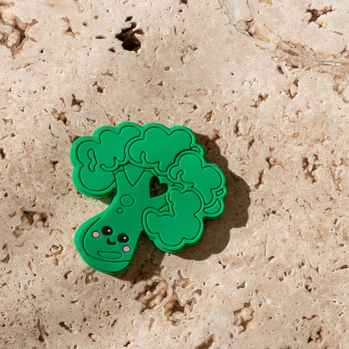 Mini and Boo broccoli teether made from soft food-grade silicone – textured for gum soothing, BPA- and PVC-free, designed to be held easily by little hands.